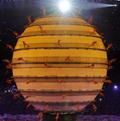 Performers walk around a floating sphere.